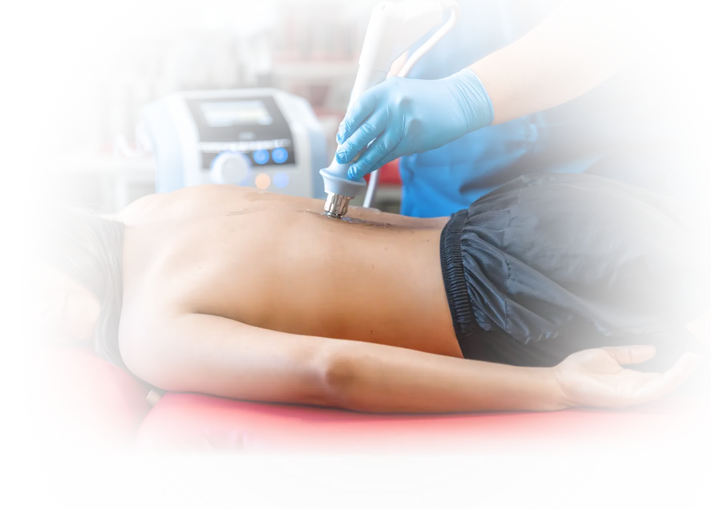 Patient lying face down receiving shockwave therapy on their back, representing non-invasive treatment for musculoskeletal injuries and chronic pain at Gallant Lion Medical in Bellingham